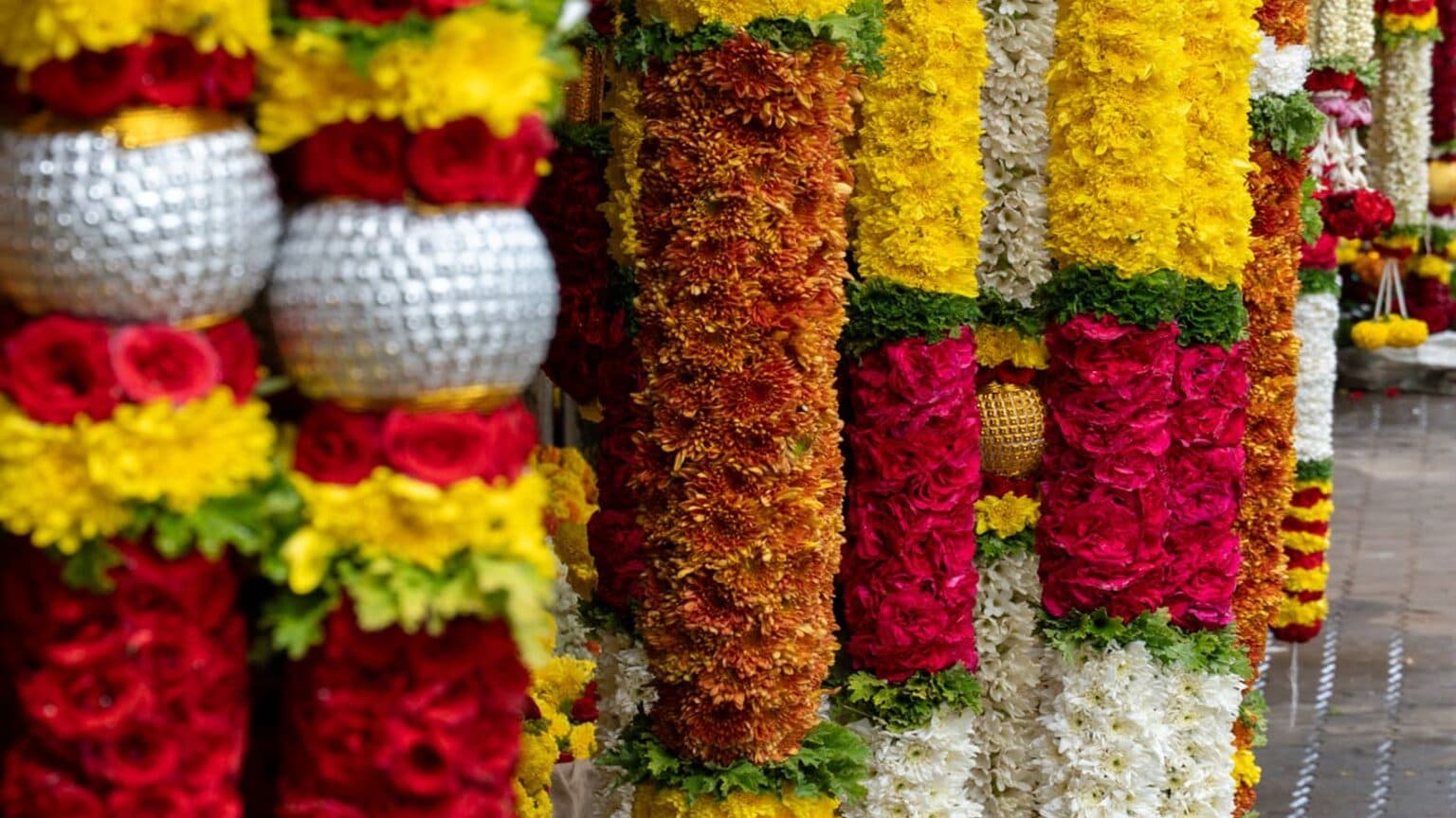 Vibrant flower garlands of red roses, yellow marigolds and white jasmine at KR Market, Bangalore